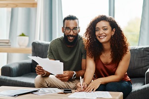 Man and Woman At Computer Looking Over Bills